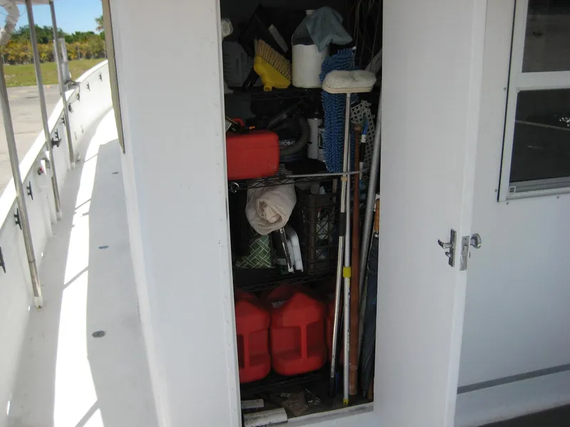 Slide: The Image of Storage compartment on 1987 Custom Pilgrim Tribute boat, filled with various equipment and supplies. - 42