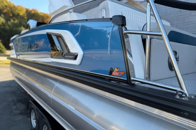 Slide: The Image of 2026 Avalon 2585 Excalibur LTD Flex Windshield boat with sleek blue design and chrome accents. - 5