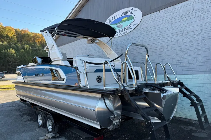 Slide: The Image of 2026 Avalon 2585 Excalibur LTD Flex Windshield pontoon boat on trailer, parked outside marine shop. - 6