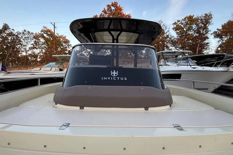 Slide: The Image of 2024 Invictus GT280S boat with sleek design, docked among trees. - 10