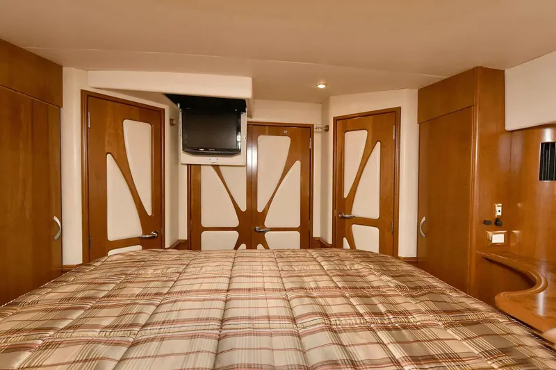 Slide: The Image of Luxurious bedroom interior of 2009 Silverton 52 Ovation yacht with modern wood paneling. - 15