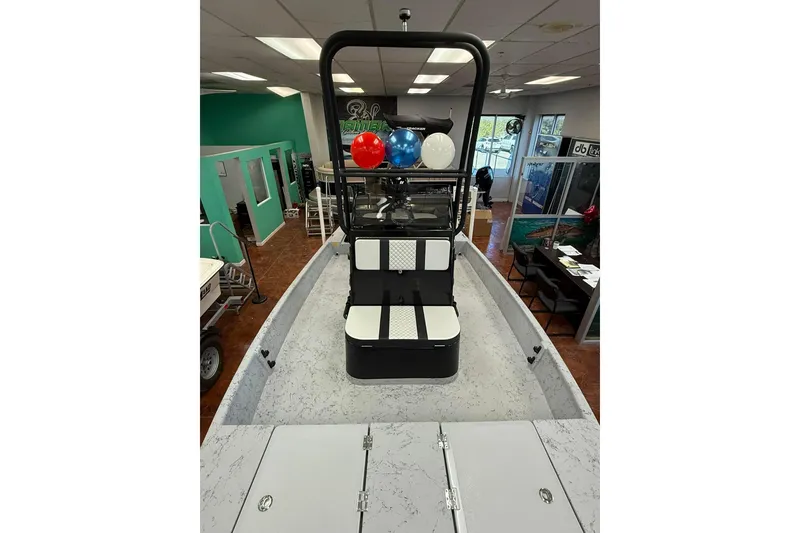 Slide: The Image of 2026 Freedom Boats 19 PATRIOT interior with seating and console, parked outdoors. - 11