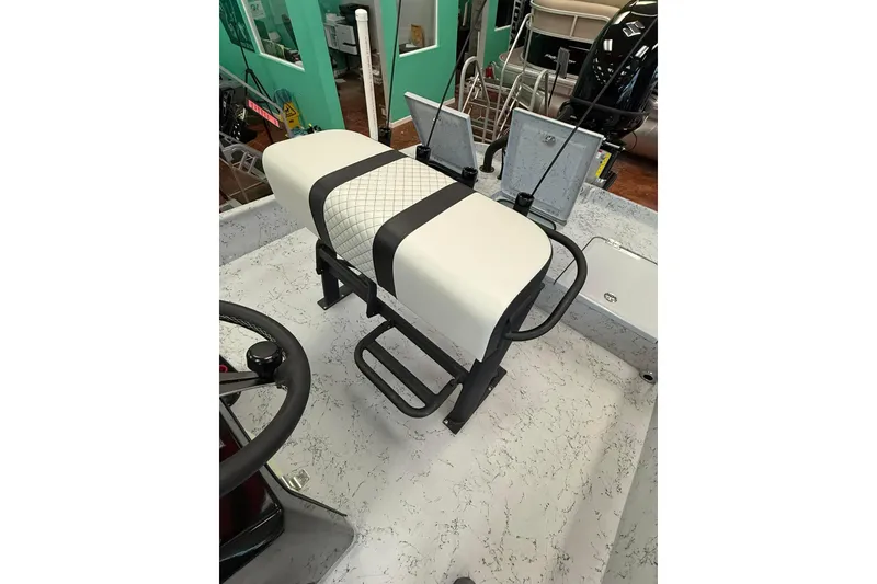 Slide: The Image of 2026 Freedom Boats 19 PATRIOT console with steering wheel and controls, docked outdoors. - 7