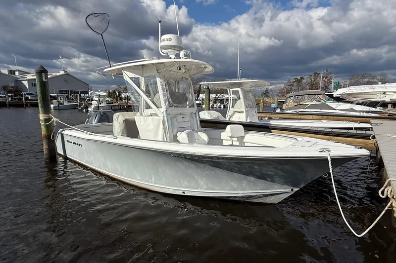 The Image of 2015 Sea Hunt Ultra 234 boat docked at marina under cloudy sky. - 0