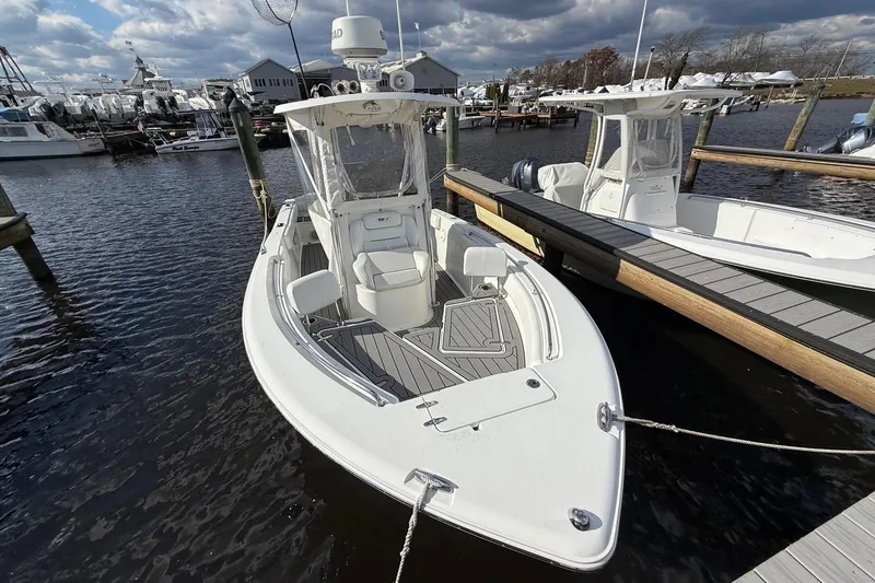 Slide: The Image of 2015 Sea Hunt Ultra 234 boat docked at marina under cloudy sky. - 1