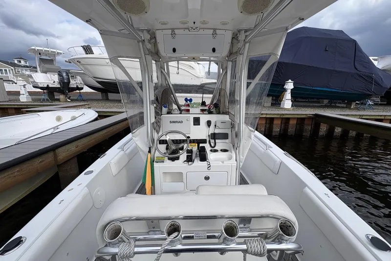 Slide: The Image of 2015 Sea Hunt Ultra 234 boat interior with steering wheel and controls at a marina. - 12