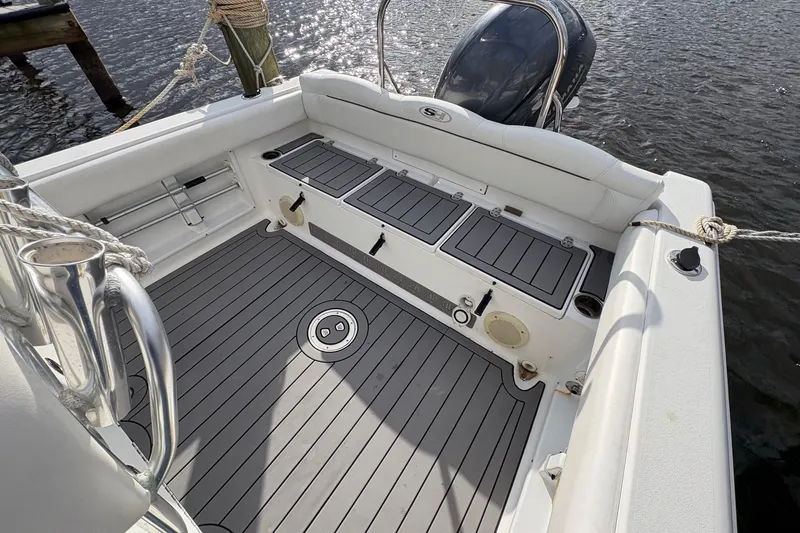 Slide: The Image of 2015 Sea Hunt Ultra 234 boat interior with gray deck and storage compartments. - 13