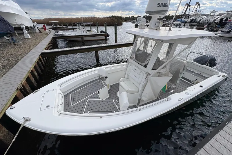 Slide: The Image of 2015 Sea Hunt Ultra 234 boat docked at marina, featuring sleek design and modern equipment. - 4