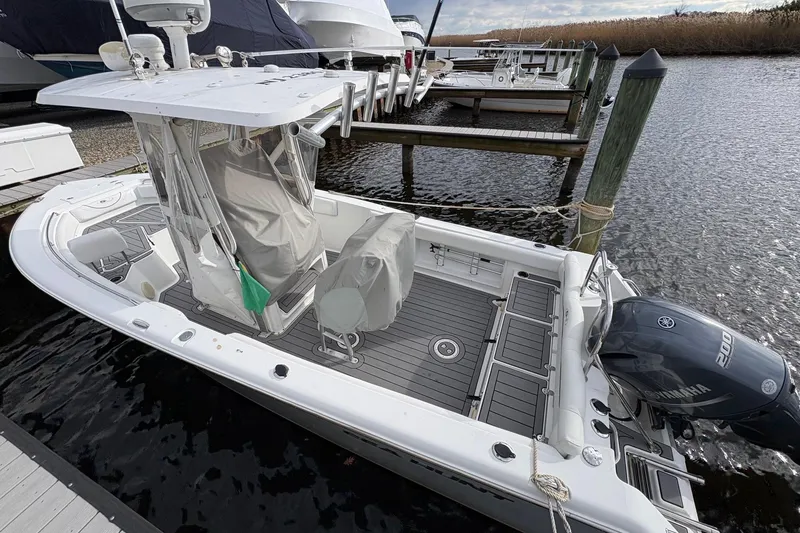 Slide: The Image of 2015 Sea Hunt Ultra 234 boat docked, featuring Yamaha 200 engine and covered seating. - 5