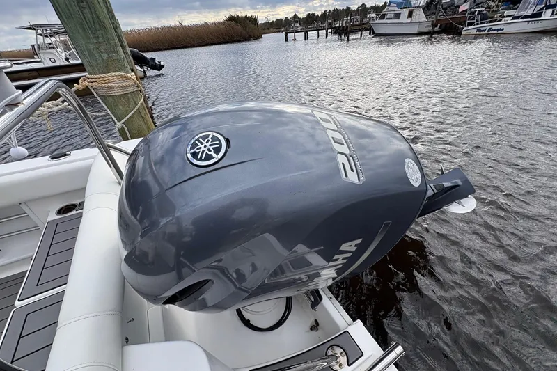 Slide: The Image of 2015 Sea Hunt Ultra 234 with Yamaha 200 outboard engine docked by the water. - 6