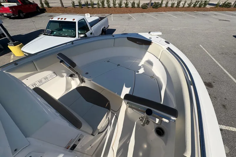 Slide: The Image of 2017 Robalo R222 boat interior with seating and storage, parked near white truck. - 11