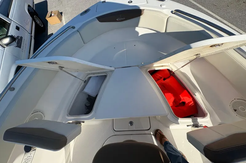 Slide: The Image of 2017 Robalo R222 boat interior with open storage compartments and visible red life jackets. - 12