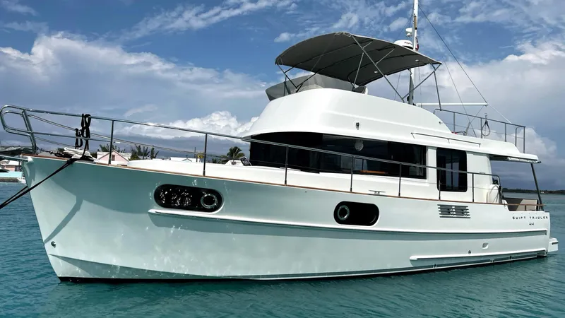 Slide: The Image of 2020 Beneteau Swift Trawler 44 on calm blue water under a partly cloudy sky. - 1