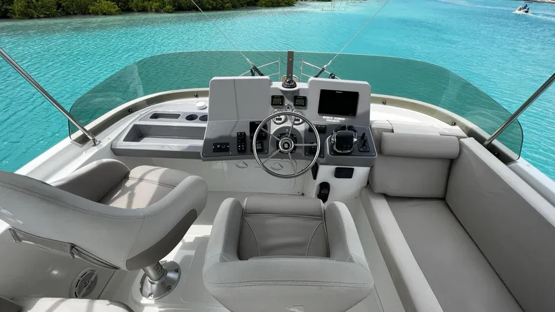 Slide: The Image of Beneteau Swift Trawler 44, 2020 model, covered seating area on deck by turquoise water. - 15