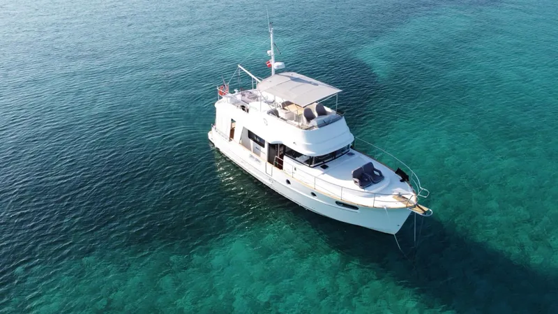 Slide: The Image of 2020 Beneteau Swift Trawler 44 on clear blue water, aerial view. - 3