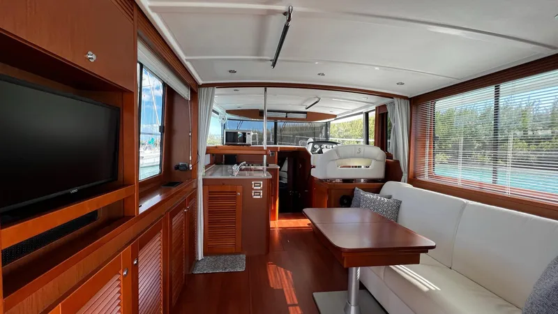 Slide: The Image of Interior of 2020 Beneteau Swift Trawler 44 with wood finish, seating, and kitchen area. - 40