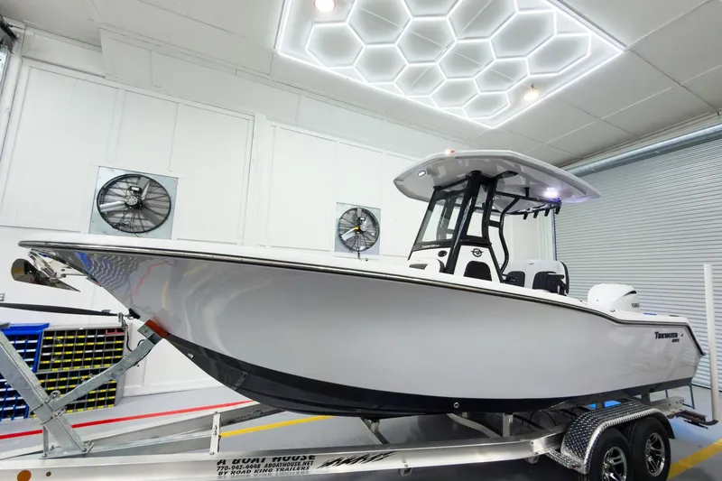 The Image of 2026 Tidewater 232 CC Adventure boat on trailer in modern showroom. - 0