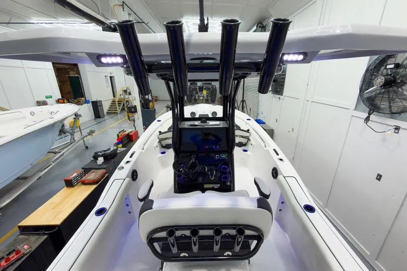 Slide: The Image of 2026 Tidewater 232 CC Adventure boat interior with modern console and seating in a workshop. - 13