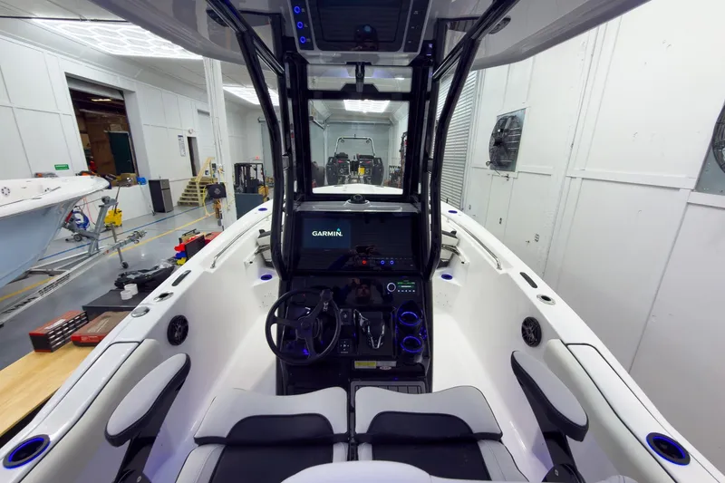 Slide: The Image of 2026 Tidewater 232 CC Adventure boat interior with Garmin navigation system in a workshop. - 16