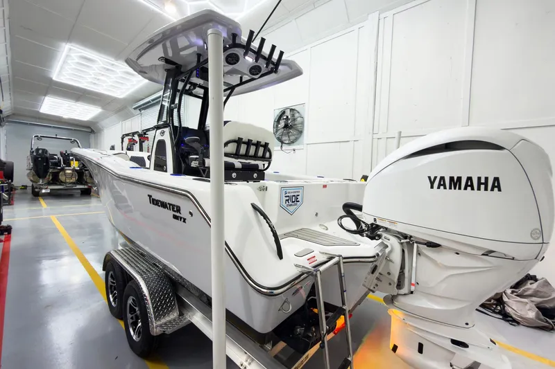 Slide: The Image of 2026 Tidewater 232 CC Adventure boat with Yamaha engine in a garage setting. - 6
