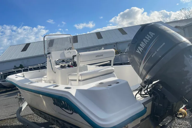 Slide: The Image of 2010 Sundance NX19 boat with Yamaha outboard motor, parked outdoors under a blue sky. - 12