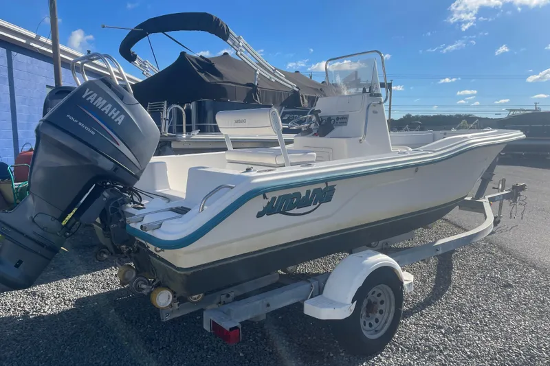 Slide: The Image of 2010 Sundance NX19 boat with Yamaha outboard motor on trailer, parked outdoors. - 13