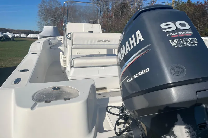Slide: The Image of 2010 Sundance NX19 boat with Yamaha 90 four-stroke engine, parked outdoors. - 6
