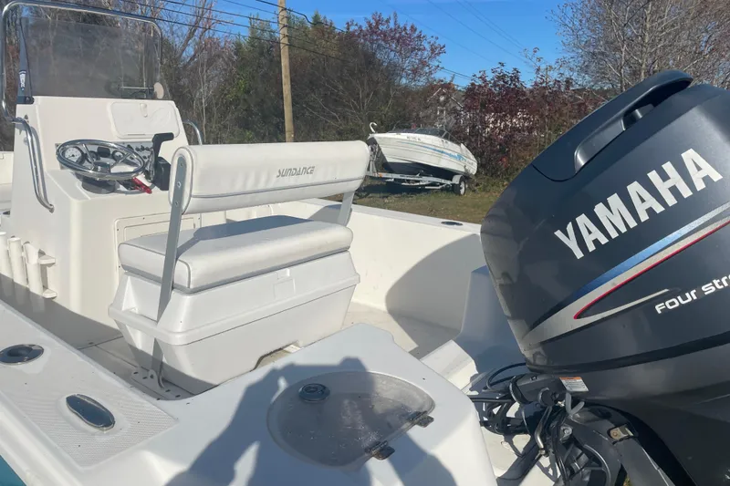 Slide: The Image of 2010 Sundance NX19 boat with Yamaha four-stroke engine, parked outdoors. - 8