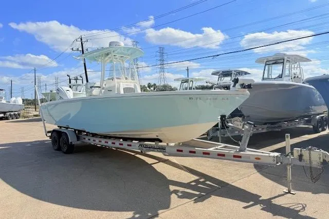Slide: The Image of 2021 Pathfinder 2700 Open boat on trailer, Yamaha engine, sunny day, blue sky, parked outdoors. - 2