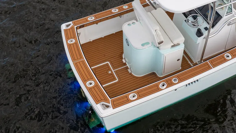 Slide: The Image of 2009 Bimini 24 Center Console boat with teak deck and blue underwater lights. - 13