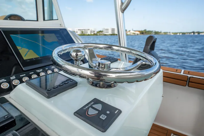 Slide: The Image of Steering wheel and controls of a 2009 Bimini 24 Center Console boat on water. - 20