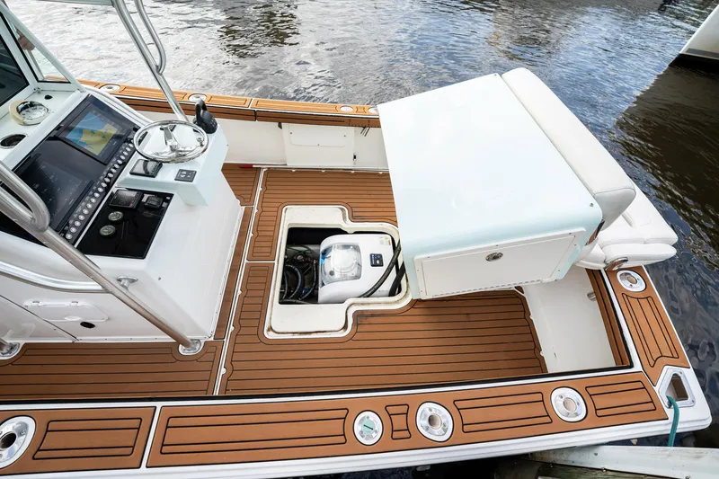 Slide: The Image of 2009 Bimini 24 Center Console boat interior with wood deck and control panel. - 27