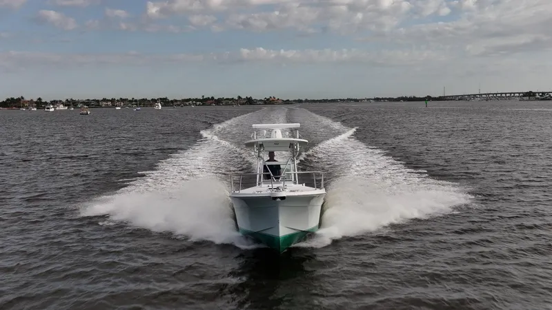Slide: The Image of 2009 Bimini 24 Center Console boat speeding on open water, creating a dynamic wake. - 3