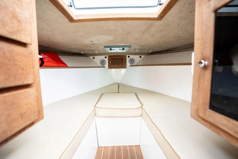 Slide: The Image of Interior cabin of 2009 Bimini 24 Center Console boat, featuring cushioned seating and wooden accents. - 31