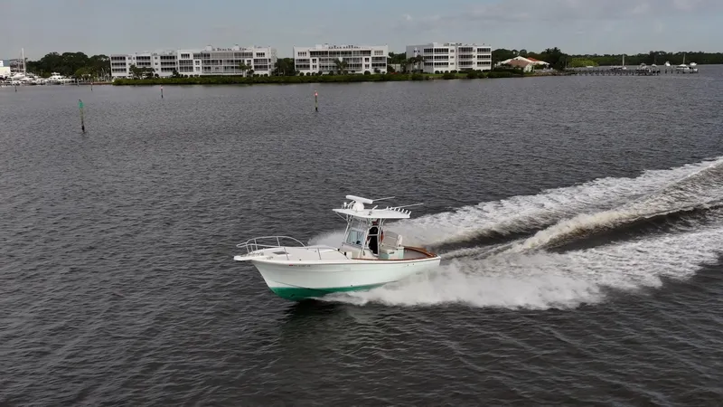 Slide: The Image of A 2009 Bimini 24 Center Console boat cruising on a calm waterway. - 5