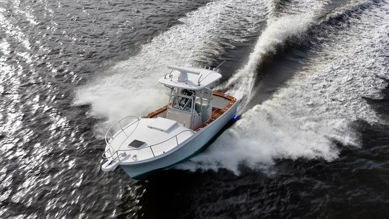 Slide: The Image of 2009 Bimini 24 Center Console boat cruising on open water, creating dynamic wake patterns. - 9