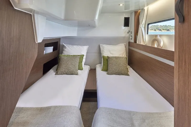 Slide: The Image of Interior cabin of 2026 Beneteau Antares 12 Fly OB with twin beds and modern decor. - 12