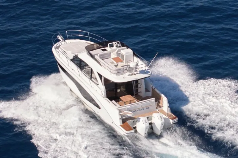 Slide: The Image of 2026 Beneteau Antares 12 Fly OB cruising on open sea, rear view. - 7