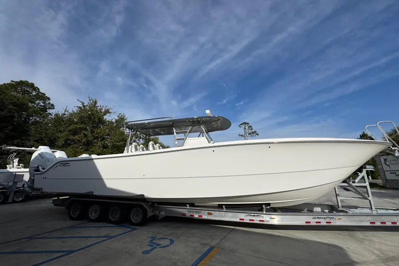 Slide: The Image of 2023 Invincible 46 Catamaran on trailer, parked outdoors under blue sky. - 11