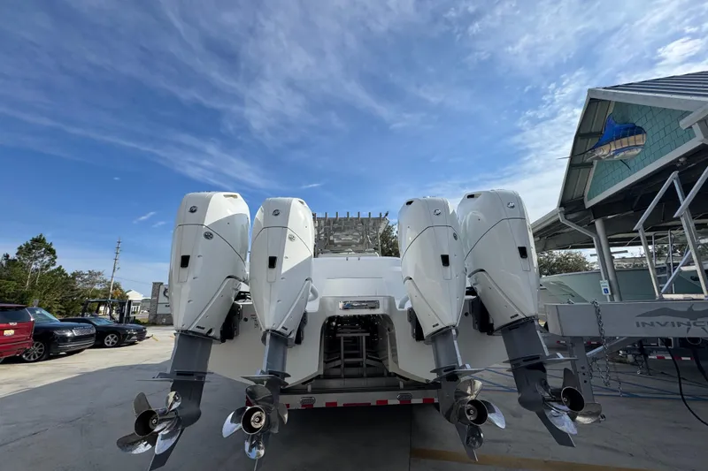 Slide: The Image of 2023 Invincible 46 Catamaran with four powerful outboard engines, docked under a clear sky. - 14