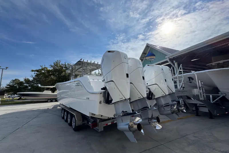 Slide: The Image of 2023 Invincible 46 Catamaran with powerful outboard engines, parked outdoors under a sunny sky. - 15