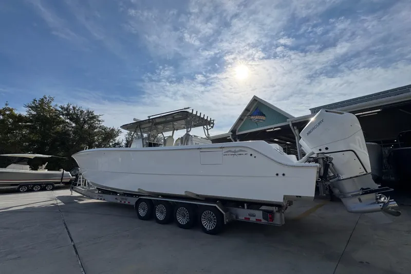 Slide: The Image of 2023 Invincible 46 Catamaran on trailer under sunny sky at marina. - 17