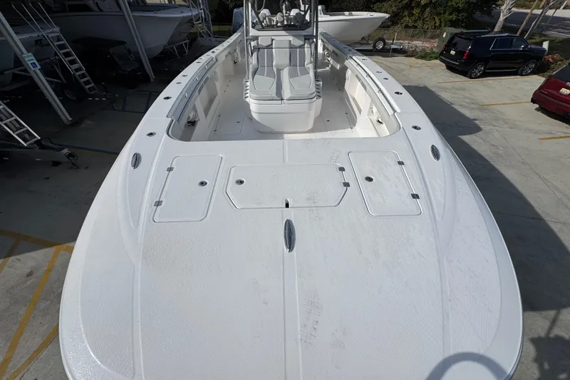 Slide: The Image of 2023 Invincible 46 Catamaran, spacious deck view, parked in a marina. - 18