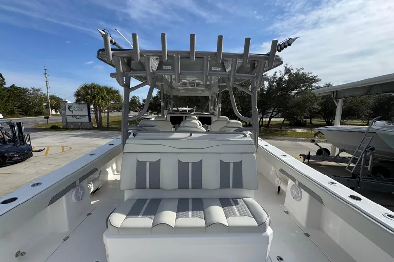 Slide: The Image of 2023 Invincible 46 Catamaran with sleek seating and modern design, docked under a clear sky. - 39