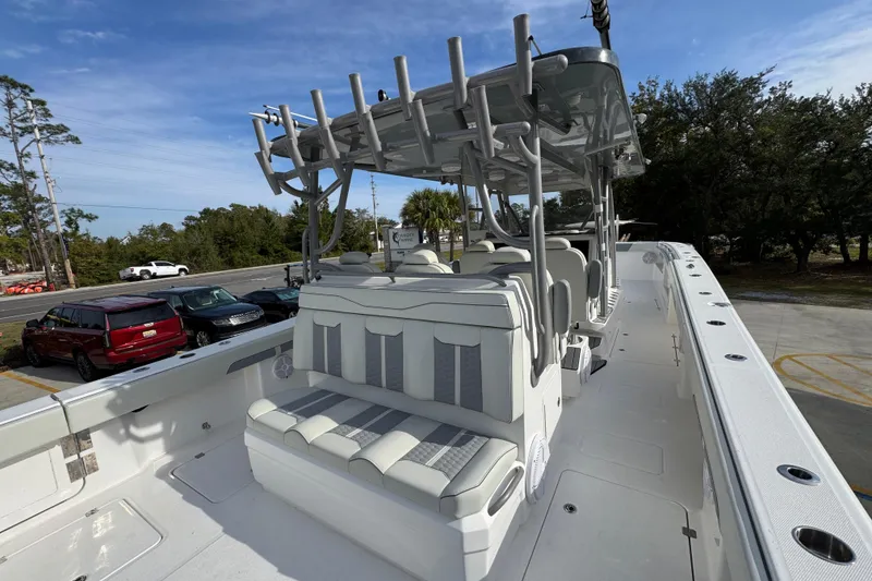 Slide: The Image of 2023 Invincible 46 Catamaran with sleek seating and modern design in a parking lot setting. - 40