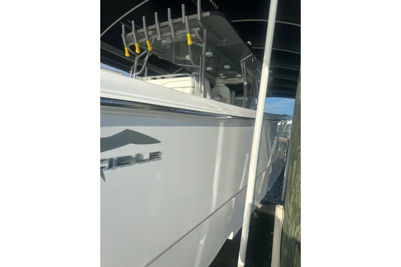 Slide: The Image of 2023 Invincible 46 Catamaran on trailer under clear sky, parked near buildings. - 8