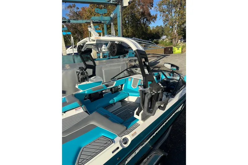 Slide: The Image of 2019 Nautique Super Air Nautique G21 boat with teal accents, docked outdoors. - 8