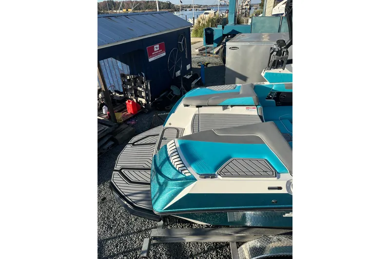 Slide: The Image of 2019 Nautique Super Air Nautique G21 boat with teal and gray interior, docked outdoors. - 9