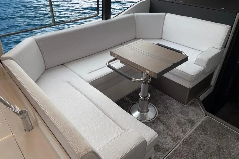 Slide: The Image of Luxurious seating area on 2026 Jeanneau NC 1295 Coupe yacht, overlooking serene ocean waters. - 20