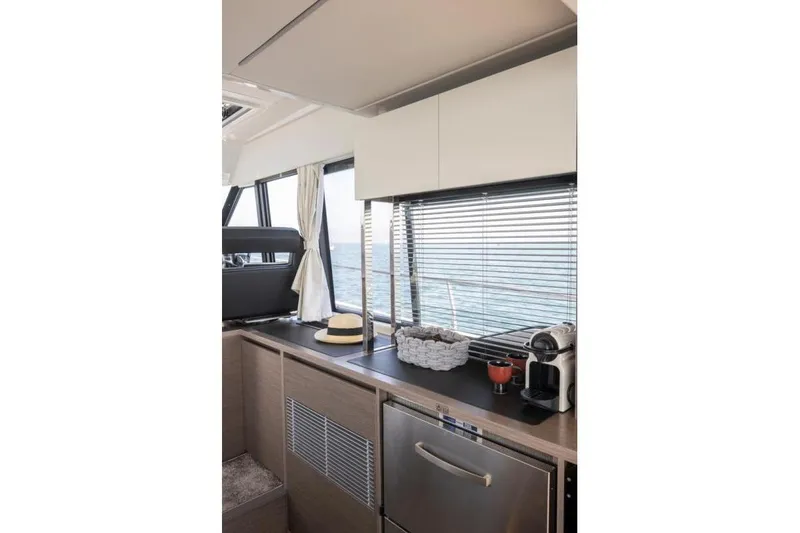 Slide: The Image of Interior of 2026 Jeanneau NC 1295 Coupe yacht with modern kitchen amenities and ocean view. - 24